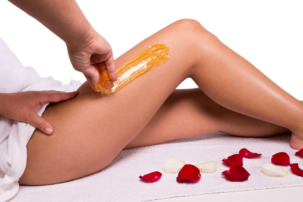 Waxing des Beines einer Frau