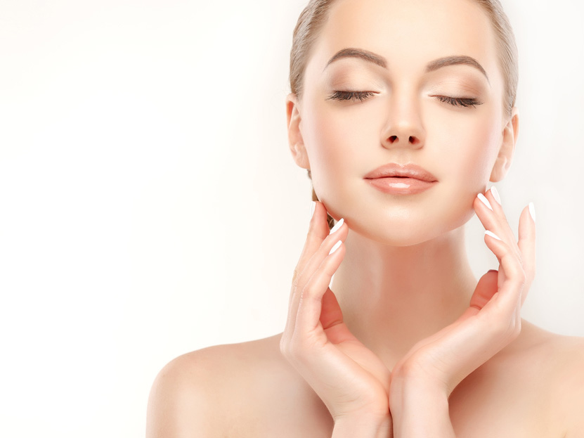 Frau mit reiner und sanfter Haut Frau mit reiner und sanfter haut, die sich mit den Händen in das Gesicht fasst.